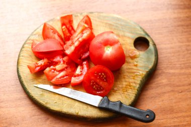 domates ve bir bıçak ıslak ahşap tahta üzerinde kesti. Yemek hazırlama