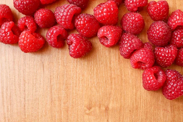 Parlak ahşap masa adam üzerinde birçok ahududu bileşimi