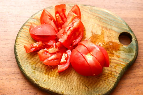 Cut red fresh tomato on wooden board. Preparing dinner, cooking — Stock Photo, Image