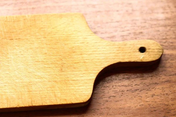 Tabla de cortar simple en la cocina sobre fondo de madera con em — Foto de Stock