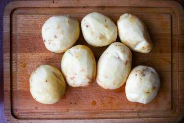 Ahşap tahta üzerinde soyulmuş patates detay kadar kapatın. Gıda hazırlama