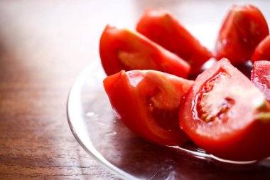 Kesilmiş domates yuvarlak daire yakın çekim üzerinde ahşap bir cam tabakta