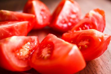 Kesilmiş domates yuvarlak daire yakın çekim üzerinde ahşap bir cam tabakta