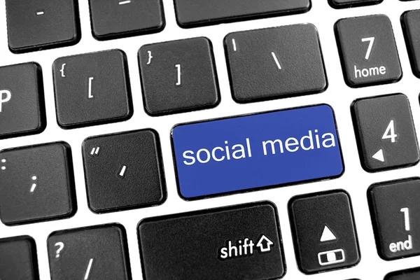 フラットな青いボタンでラップトップの黒のモダンなキーボード: 社会 — ストック写真