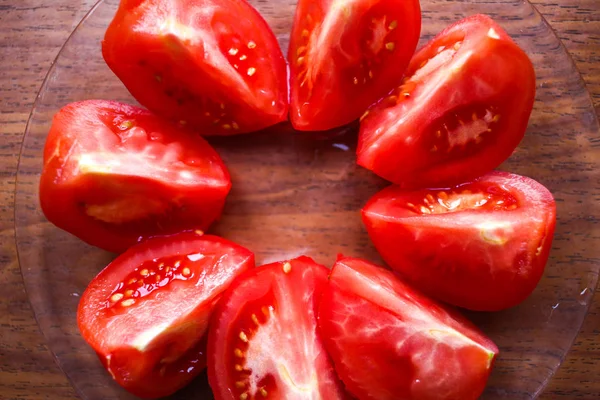 Runder Kreis geschnittener Tomaten aus nächster Nähe auf einem Glasteller auf hölzernen — Stockfoto