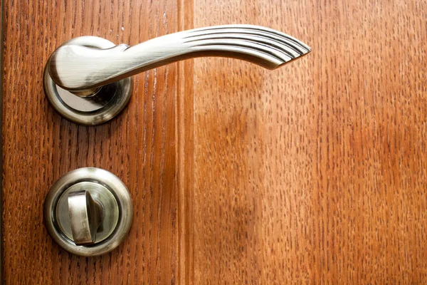 Beautiful decorated door handle on dark wooden door — Stock Photo, Image