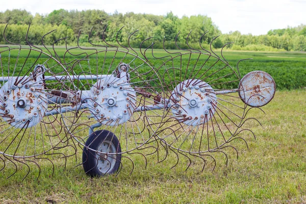 Egge auf der grünen Wiese. Landwirtschaftliche Arbeiten im Sommer hautnah — Stockfoto