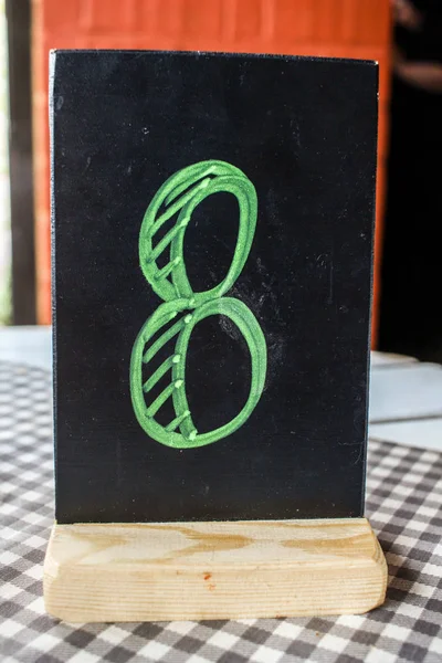 Número 8 ocho en placa de tablero negro en mantel a cuadros, número de pedido — Foto de Stock