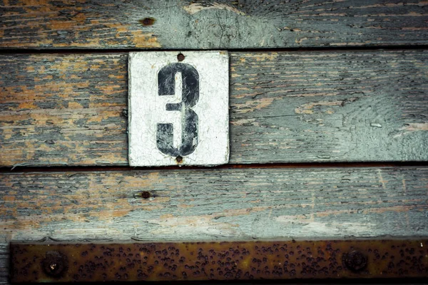 Placa de número de casa vieja 3 en la puerta pintada verde grueso viejo — Foto de Stock