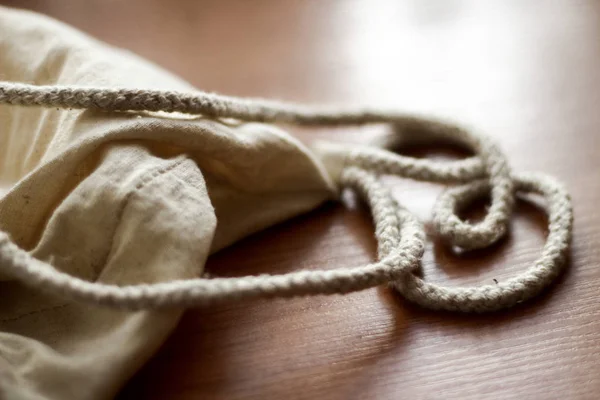 White cotton sack on wooden back ground close up