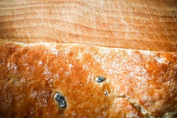 Хлібна булочка з оливками на дерев'яній дошці на дерев'яному фоні закрити — стокове фото