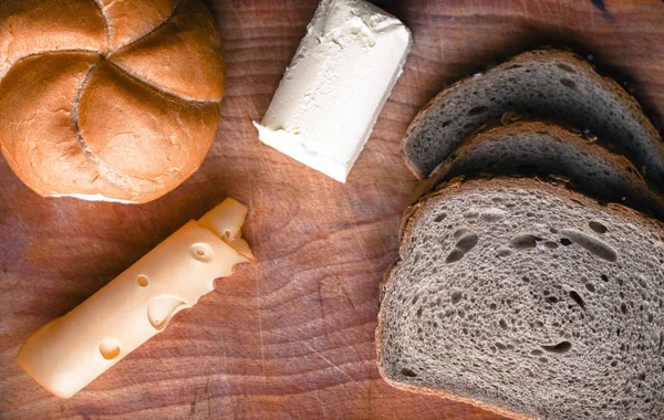 Свіжоспечений коричневий хліб, шматочок копченого жовтого сиру — стокове фото