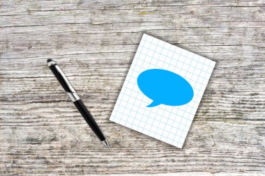 Kareli kağıt Not kalem ile mavi bulut sembolü. Ahşap backg