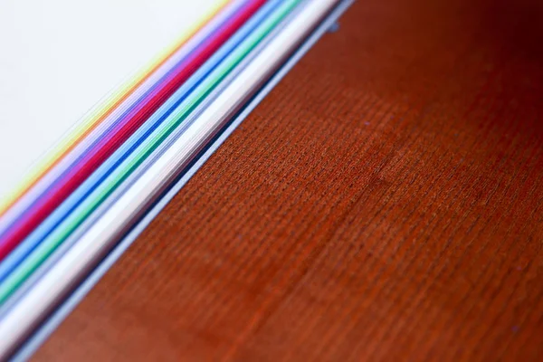Many colorful paper sheets for drawing on wooden background. Abs