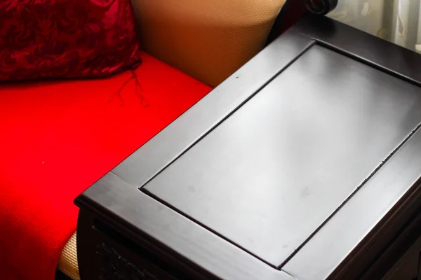 Nahaufnahme Detail des Zimmers mit einem stilvollen Holztisch roten Kissen — Stockfoto