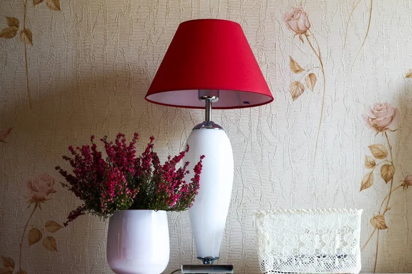 Rote Lampe und weiße Vase mit Blumen in einem Raum mit weichem Licht o — Stockfoto