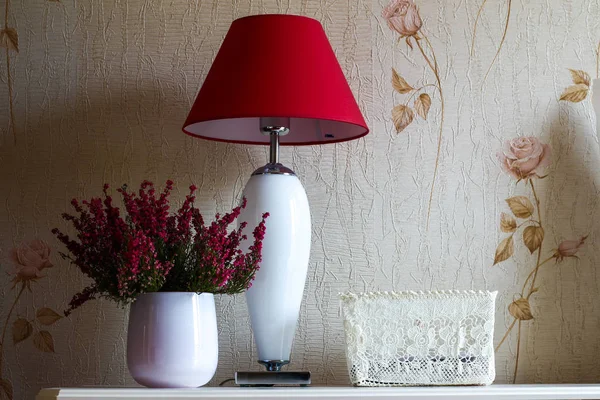 Rote Lampe und weiße Vase mit Blumen in einem Raum mit weichem Licht o — Stockfoto