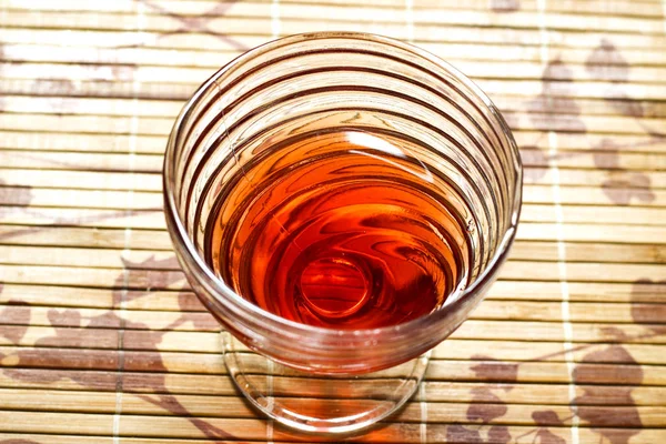 Red juice in a nice stylish glass on wooden bamboo stand — Stock Photo, Image