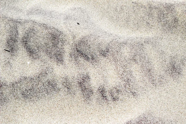 Arena sucia con patrón de rayas negras en el fondo de la playa — Foto de Stock