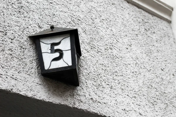 Farol de calle con número de casa colgando fuera del edificio en —  Fotos de Stock