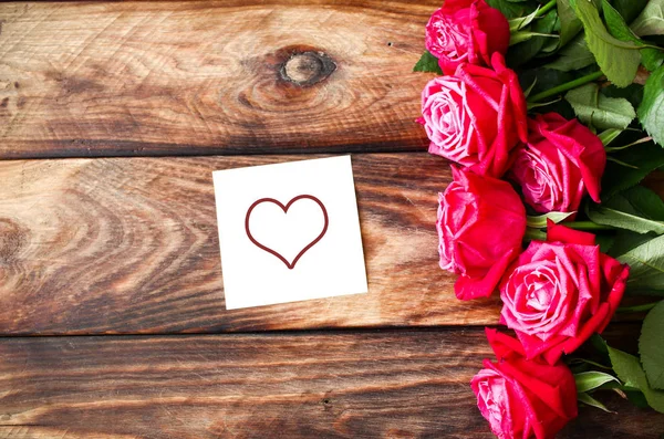 Bukiet czerwonych róż na podłoże drewniane. Liczby na Walentynki Obraz Stockowy