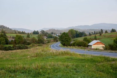 Köy ashalted yol. Yeşil alan. Dağları.