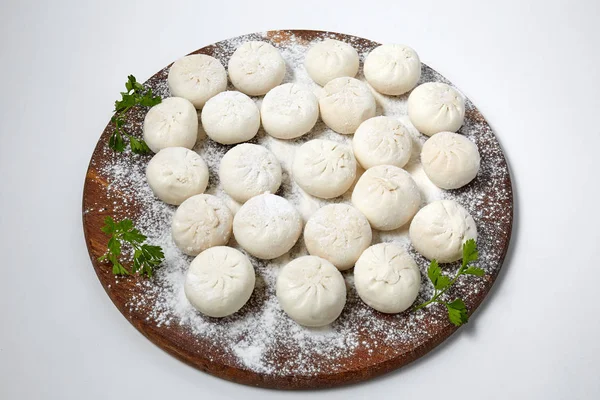 Khinkali on wooden plate with flour. Pelmeni — Stock Photo, Image