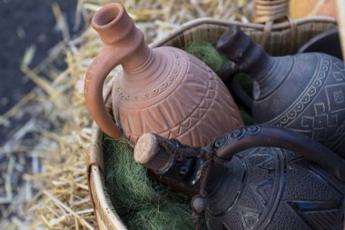 kabak ve saman üzerinde arka plan ile sepet içinde farklı seramik crocks