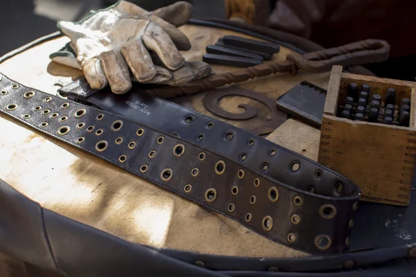 blacksmith working gloves and belt with different instruments on the table