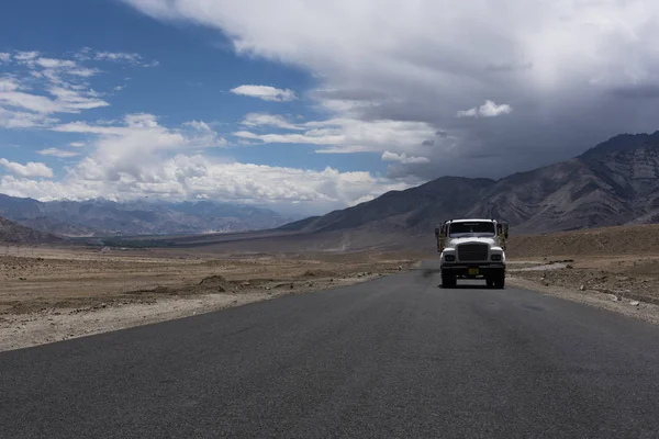 Caminhão movendo-se em uma estrada reta em planícies do deserto de Ladakh — Fotografia de Stock