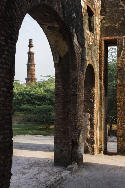 Qutub Minar como se ve a través de las ruinas del parque arqueológico mehrauli . — Foto de Stock