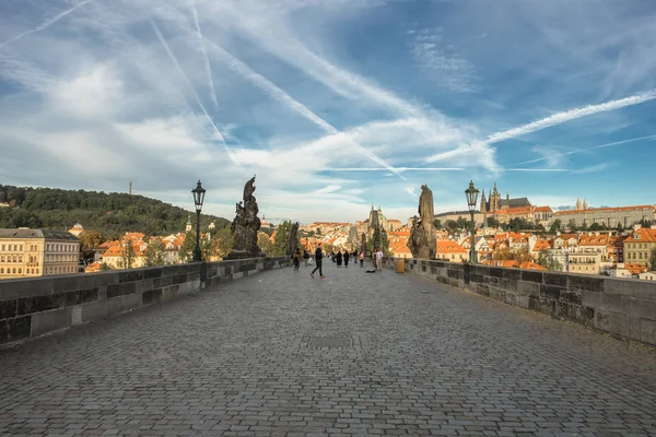 Prague, République tchèque, 29 septembre 2016 : quelques touristes sur le pont Charles au lever du soleil, l'une des destinations les plus populaires parmi les touristes . — Photo