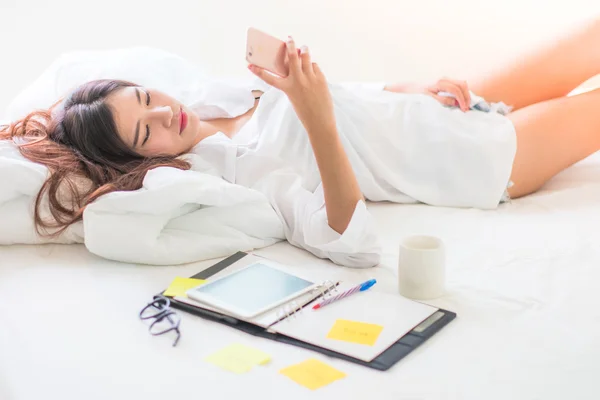Asian woman working on the bed. Stock Picture