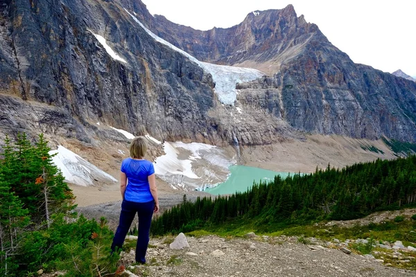 Mujer de pie sobre rocas junto al lago glaciar . — Foto de Stock