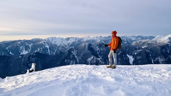 Man sneeuwschoenen op de bergtop. — Stockfoto