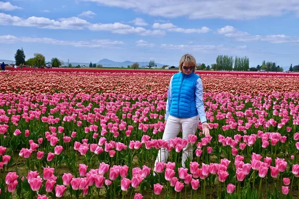 Junge blonde Frau zwischen Blumen. — Stockfoto