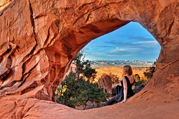 Woman by natural arch in Arches National park. — Stock Photo, Image