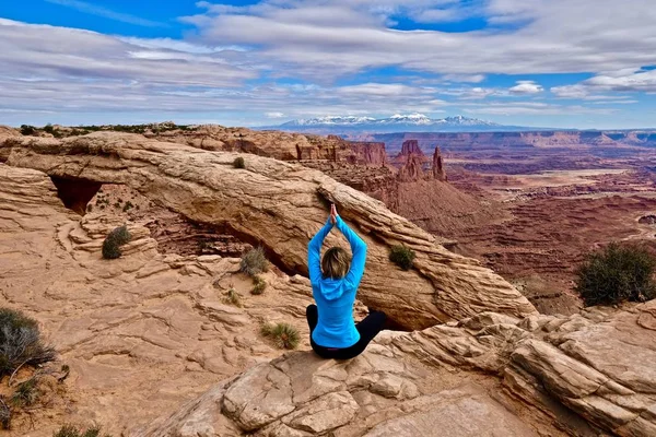 Mujer joven meditando en el acantilado por Mesa Arch . — Foto de Stock