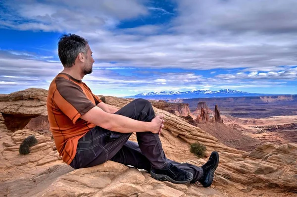 Hombre barbudo hipster en el acantilado mirando las vistas del cañón . — Foto de Stock