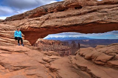 Cliff Mesa Arch tarafından oturan kadın hipster. 