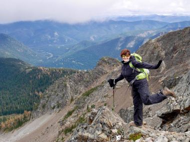 Gülümseyen kadın dağlarda hiking. 