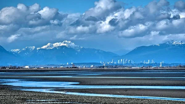 Langit kota, gunung bersalju dan pasang surut di Teluk Boundary . — Stok Foto