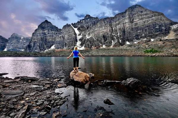 Mujer joven meditando junto al lago en el Valle de los Diez Picos . — Foto de Stock