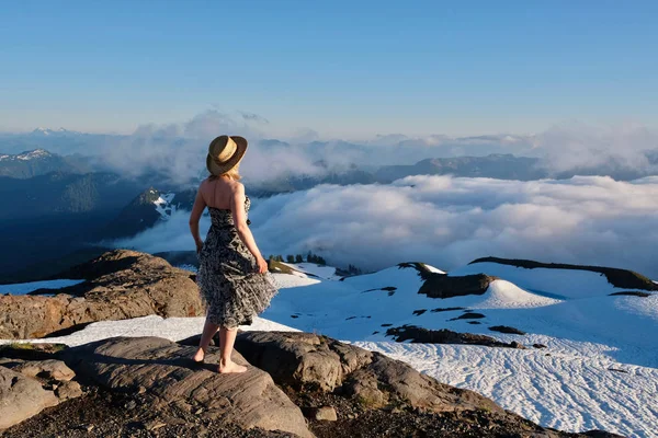 Vrouw op de bergtop genieten van mooie uitzichten. — Stockfoto
