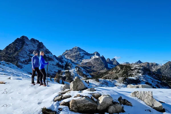 Grupo de personas en la cima de la montaña disfrutando de las vistas panorámicas desde arriba. Senderismo de invierno con raquetas de nieve en Cascade Mountains cerca de Seattle, Winthrop y Leavenworth. Pacific Northwest. Estados Unidos . — Foto de Stock