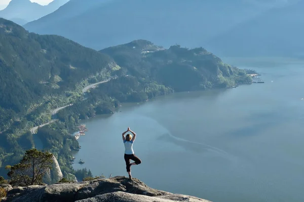 Mujer meditando en la cima de la montaña sobre el océano . — Foto de Stock