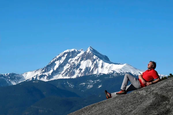 Man op de bergtop tegen besneeuwde Diamond Head piek. — Stockfoto