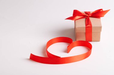 Kırmızı kalpler kurdelelerden ve hediye kutusundan beyaz arka planda