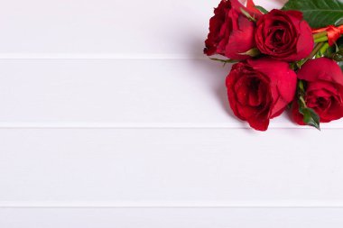 Red rose bouquet on white wood background
