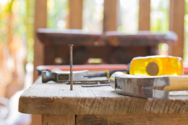 Çekiçle tahtaya çivi çakar